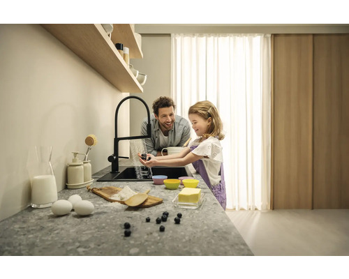 Scène dans une cuisine avec un père et sa fille lavant des myrtilles sous un robinet pendant qu''ils cuisinent ensemble