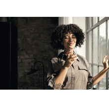 Femme avec verre d''eau à la fenêtre
