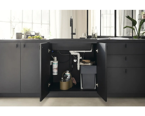 Küchenspüle mit geöffnetem Unterschrank, der Mülleimer, Wasserfilter und Reinigungsutensilien zeigt