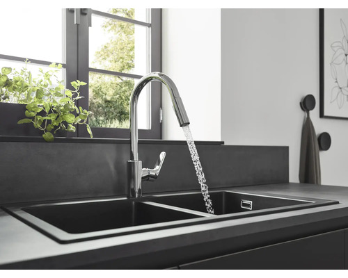 Küchenspüle mit Wasserhahn und fließendem Wasser in einer hellen Küche