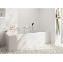 Baignoire blanche avec robinetterie et douchette dans une salle de bain lumineuse.