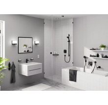 Salle de bain lumineuse avec lavabo, miroir, douche et baignoire au design moderne.