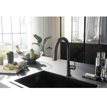 Moderne Küche mit schwarzem Spülbecken und Wasserhahn, ergänzt durch frisches Gemüse und Kräuter.