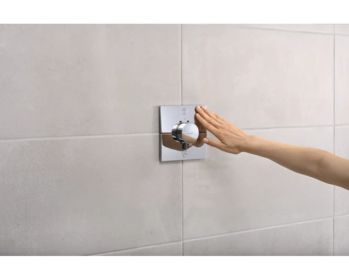 Thermostat apparent avec main monté sur un mur carrelé