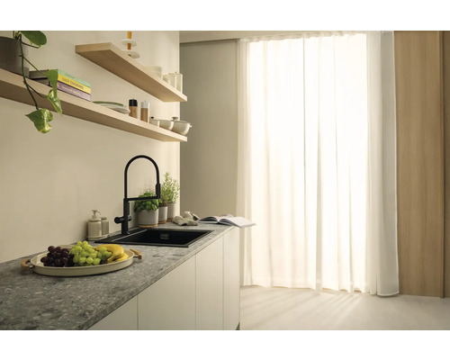 Scène de cuisine avec évier, robinet et éléments décoratifs sur un plan de travail