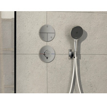 Robinet de douche avec douchette de tête et éléments de commande sur un mur carrelé