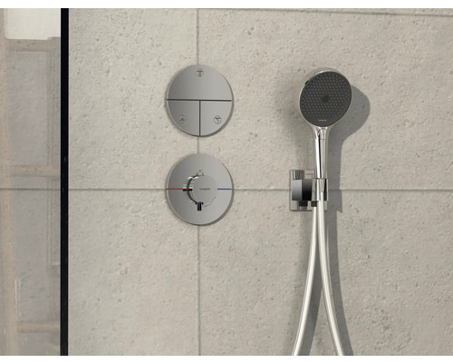 Robinet de douche avec douchette de tête et éléments de commande sur un mur carrelé