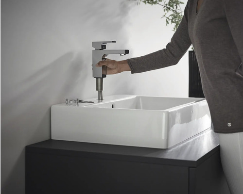 Installation d''un robinet sur un lavabo blanc dans la salle de bain.