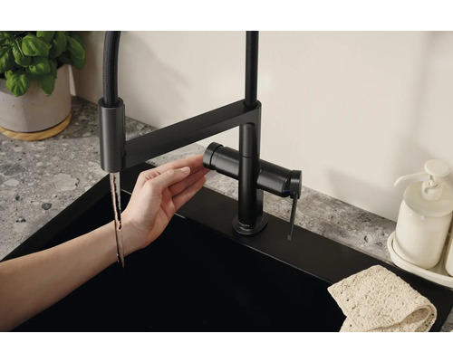 Mitigeur de cuisine pivotant avec douchette et design moderne sur un évier.