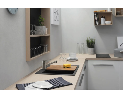 Küchenszene mit Spüle, Armatur, Geschirr und Regalen zur Aufbewahrung