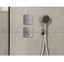 Brausegarnitur mit Kopfbrause, Bedienelementen und Thermostat an einer Wand