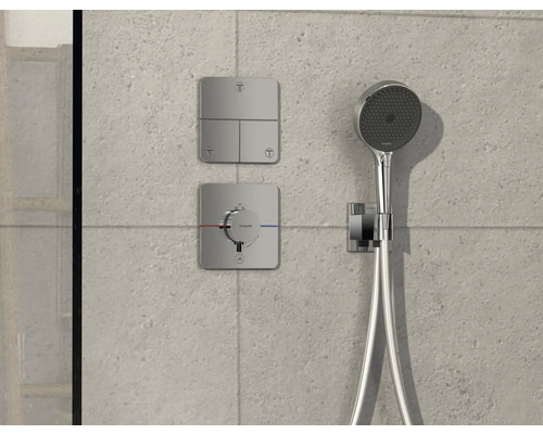 Brausegarnitur mit Kopfbrause, Bedienelementen und Thermostat an einer Wand