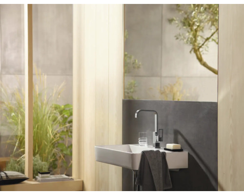 Salle de bain moderne avec lavabo, robinet, miroir et éléments décoratifs