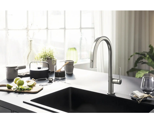 Küchenspüle mit Armatur auf einer Arbeitsplatte mit Küchenutensilien und Zutaten.