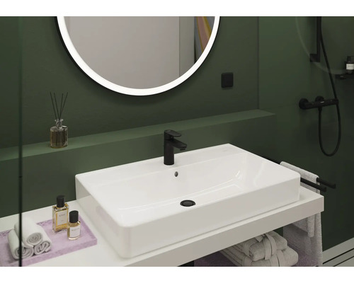 Badezimmer mit Waschbecken, Armatur, Spiegel und Handtüchern