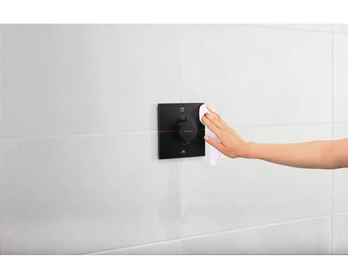 Mitigeur de douche monocommande en cours de nettoyage dans la salle de bains.