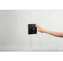 Aufputz-Thermostatarmatur mit Hand, installiert an der Wand im Badezimmer