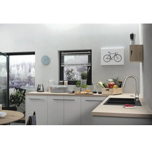 Helle Küche mit Spüle, Armatur, Arbeitsplatte, Küchenutensilien, Dekoration und Fenster.