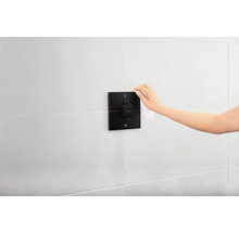 Hand reinigt Thermostatbatterie im Badezimmer