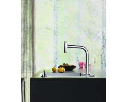 Küchenszene mit Spültischarmatur, Spülbecken und Küchenutensilien auf einer Arbeitsplatte.