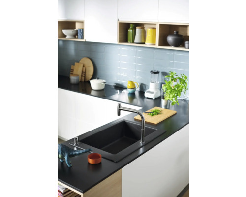 Cuisine moderne avec plan de travail foncé, évier et robinet