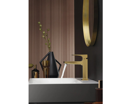 Badezimmer Waschbecken mit goldener Armatur und fließendem Wasser