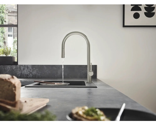 Scène de cuisine avec robinet d''évier, évier et ustensiles de cuisine sur un plan de travail.