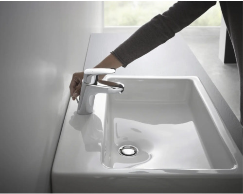 Waschbecken mit Armatur und Hand, im Badezimmer