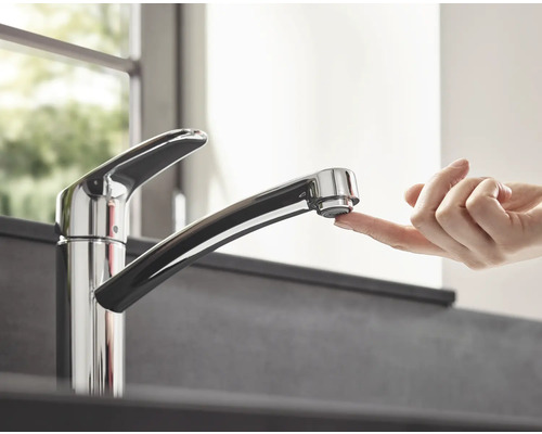 Küchenarmatur mit Finger auf dem Auslauf