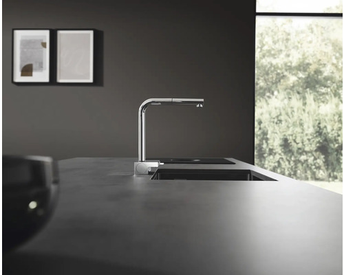 Scène de cuisine avec évier, robinet et plaque de cuisson au design moderne.