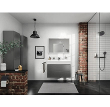 Modernes Badezimmer mit Waschtisch, Spiegel, Dusche und grauen Schränken vor einer Backsteinwand