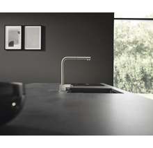 Küchenszene mit Spüle, Wasserhahn und zwei gerahmten Bildern an der Wand