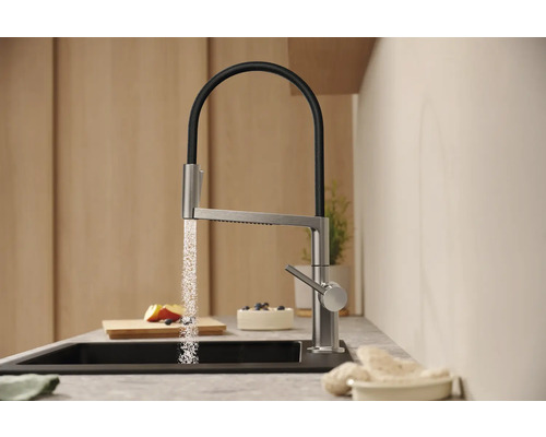 Küchenarmatur mit schwenkbarem Auslauf und Wasserstrahl über einer Spüle