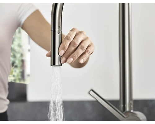 Femme actionnant un robinet de cuisine avec douchette