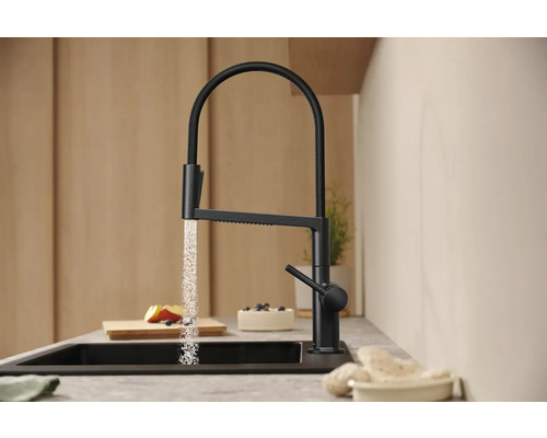 Schwarzer Küchenarmatur mit fließendem Wasser in einer modernen Küche.