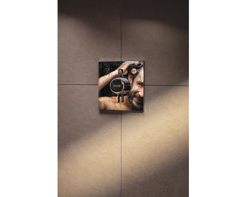 Mitigeur thermostatique encastré dans une salle de bains avec un homme souriant sous la douche