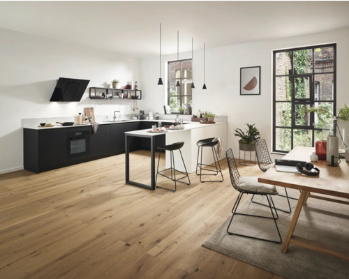 Cuisine claire avec kitchenette, îlot de cuisine, table à manger et chaises.