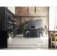 Cuisine moderne avec îlot central, tabourets de bar et mur de briques