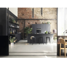 Cuisine lumineuse de style loft avec îlot de cuisine, tabourets de bar, kitchenette et mur de briques