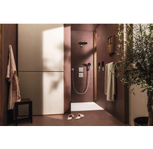 Badezimmer mit Dusche, Handtüchern, Hocker, Bademantel und Olivenbaum für eine angenehme Atmosphäre