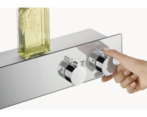 Mitigeur thermostatique apparent avec gel douche et main ajustant la température