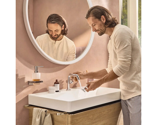 Mann wäscht Rasierer an einem Waschbecken im Badezimmer mit Spiegel und Armatur