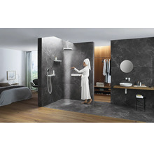 Badezimmer mit Dusche, Waschtisch und angrenzendem Schlafzimmer.