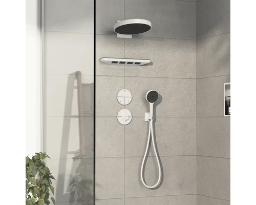Système de douche avec pomme de tête, douchette à main et éléments de commande sur un mur carrelé