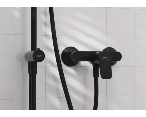 Schwarze Duscharmatur von Hansgrohe an einer gefliesten Wand