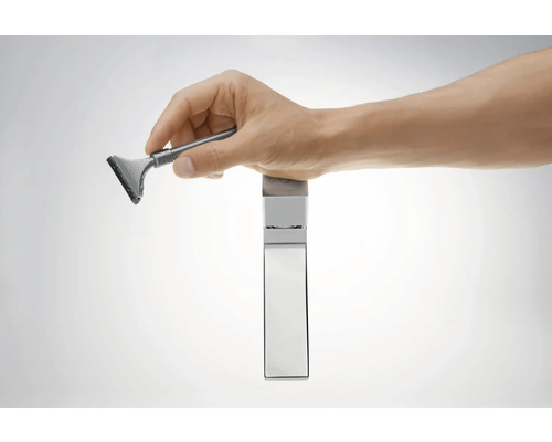 Hand hält Duschabzieher an einer Armatur