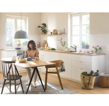 Helle Küche mit Esstisch und sitzender Person