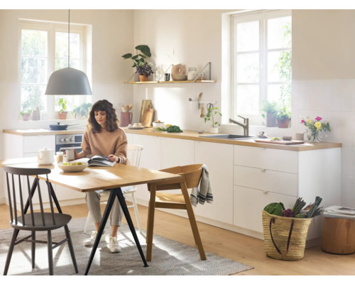 Cuisine lumineuse avec table à manger et personne assise