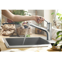 Küchenszene mit Spültischarmatur aus Metall und fließendem Wasser