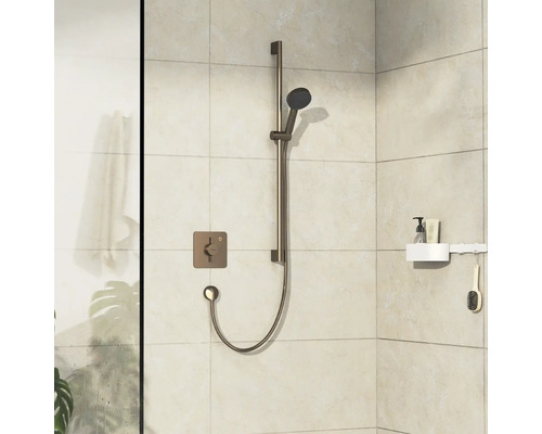 Robinet de douche avec douchette à main et étagère sur un mur carrelé